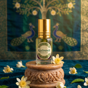 Kadamb attar bottle for Thakorji seva displayed on a carved stand with flowers in a devotional setting