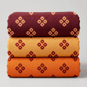 Stacked set of three printed vastra rolls with geometric motifs for Pushtimarg shringar and Thakorji temple dressing.