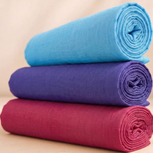 Three rolled plain vastra pieces stacked as a Pushtimarg seva combo for Thakorji shringar and temple dressing