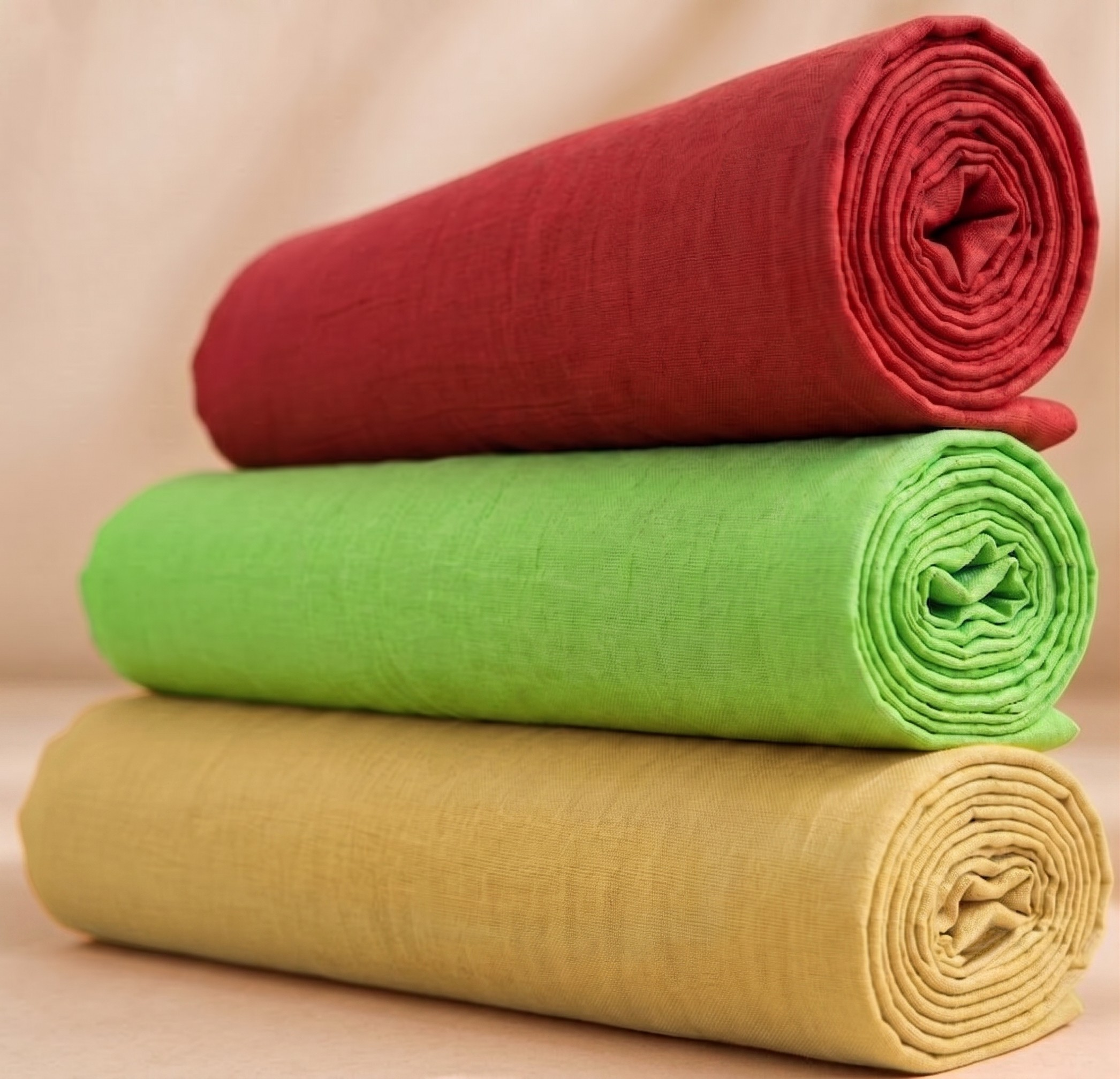 Three rolled plain vastra fabrics arranged in a stacked bundle for Thakorji shringar and devotional dressing