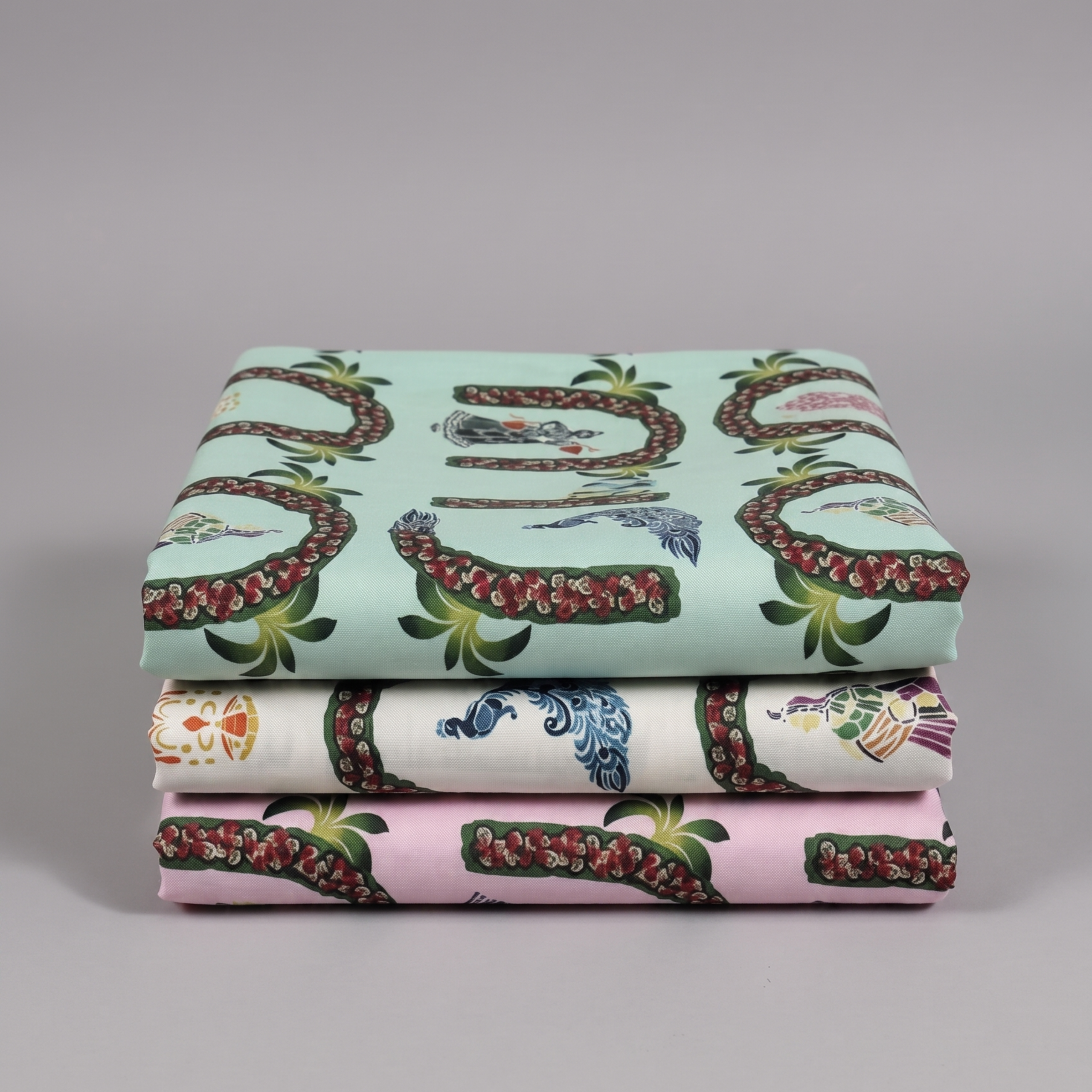Three folded printed vastra pieces with pichwai garland and peacock motifs, made for Thakorji shringar use.