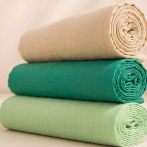 Three neatly rolled plain vastra pieces stacked as a Thakorji shringar combo set for devotional dressing