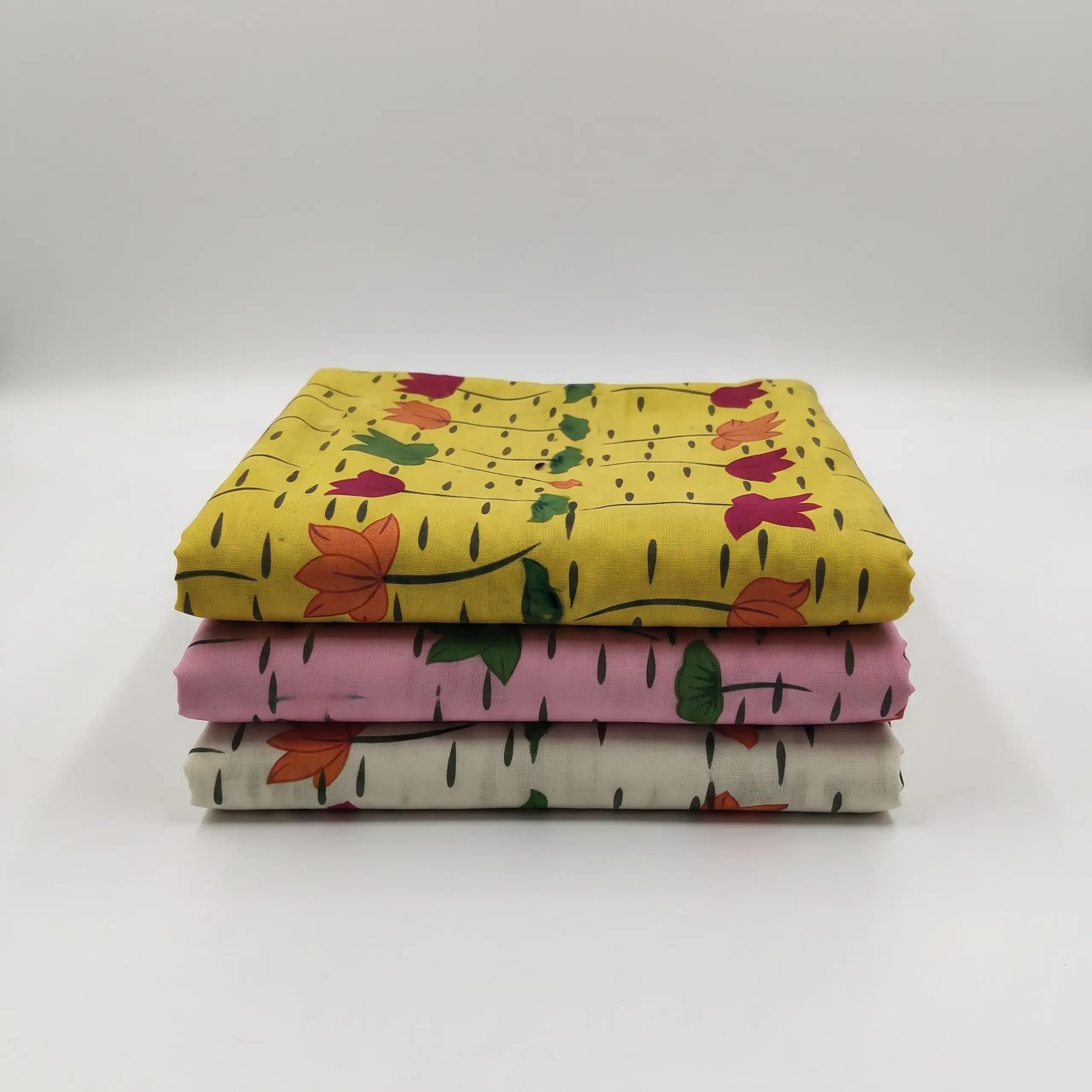 Stack of three folded printed vastra pieces for Thakorji shringar, arranged as a devotional fabric combo set.