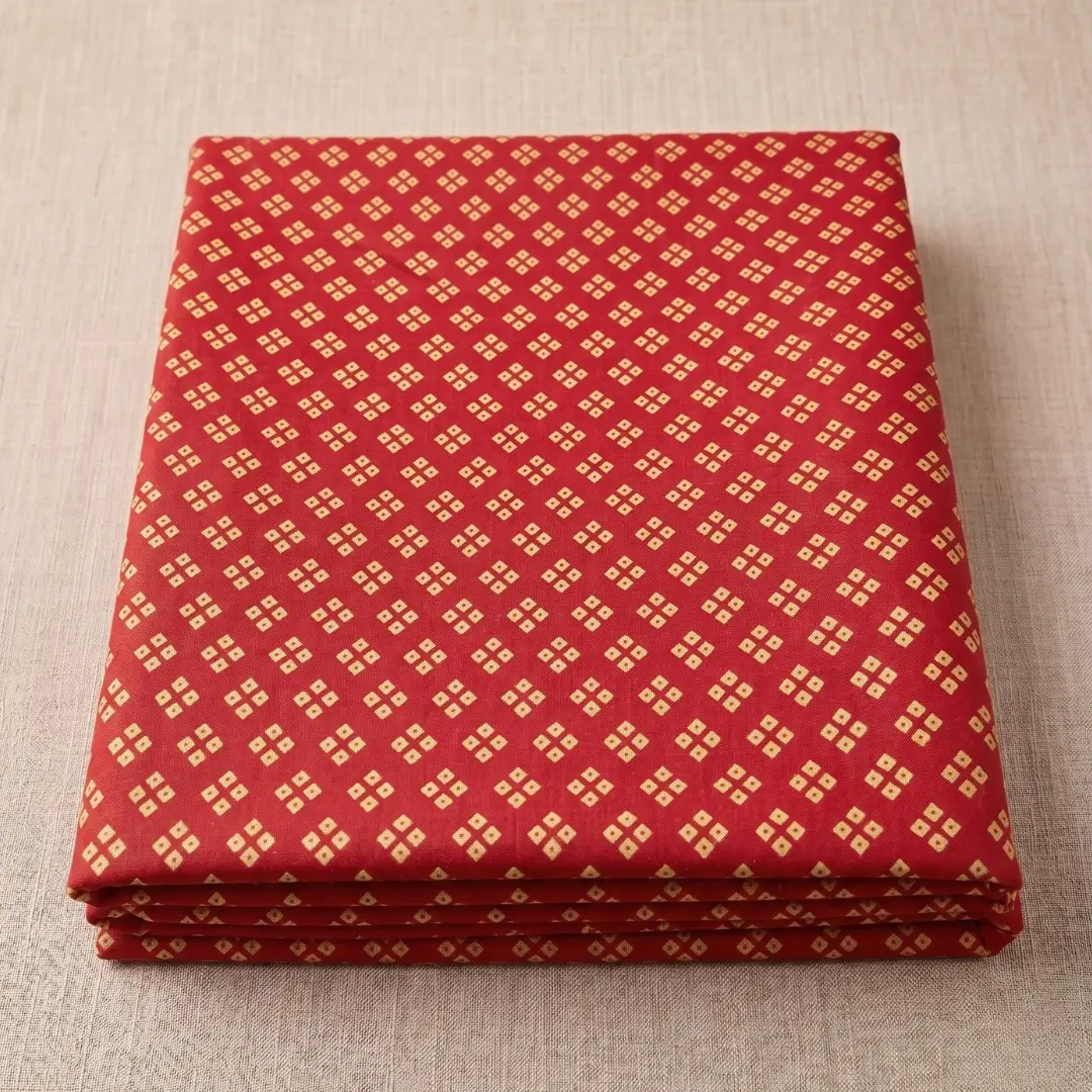 Soft folded red cloth featuring yellow dots for bandhani vastra for pushtimarg seva.