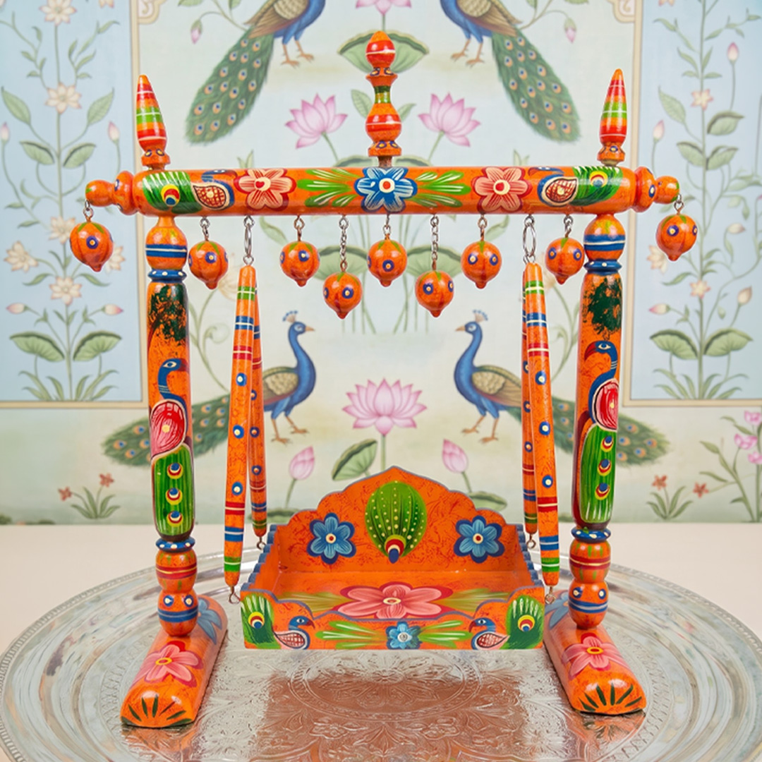 Hand-painted wooden hindola jhula with peacock design for pushtimarg seva.
