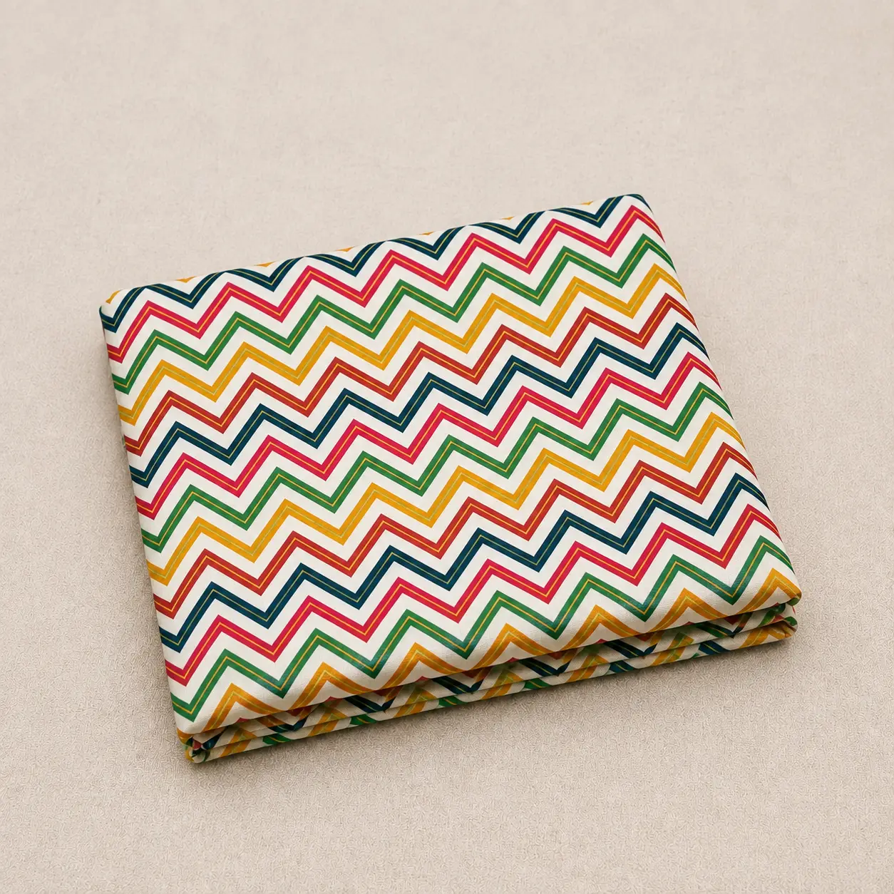 Folded white leheriya fabric adorned with colorful yellow green blue and magenta chevron stripes