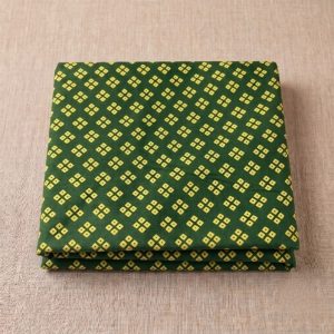 Folded green bandhani vastra for pustimarg seva featuring cream four-dot motifs.