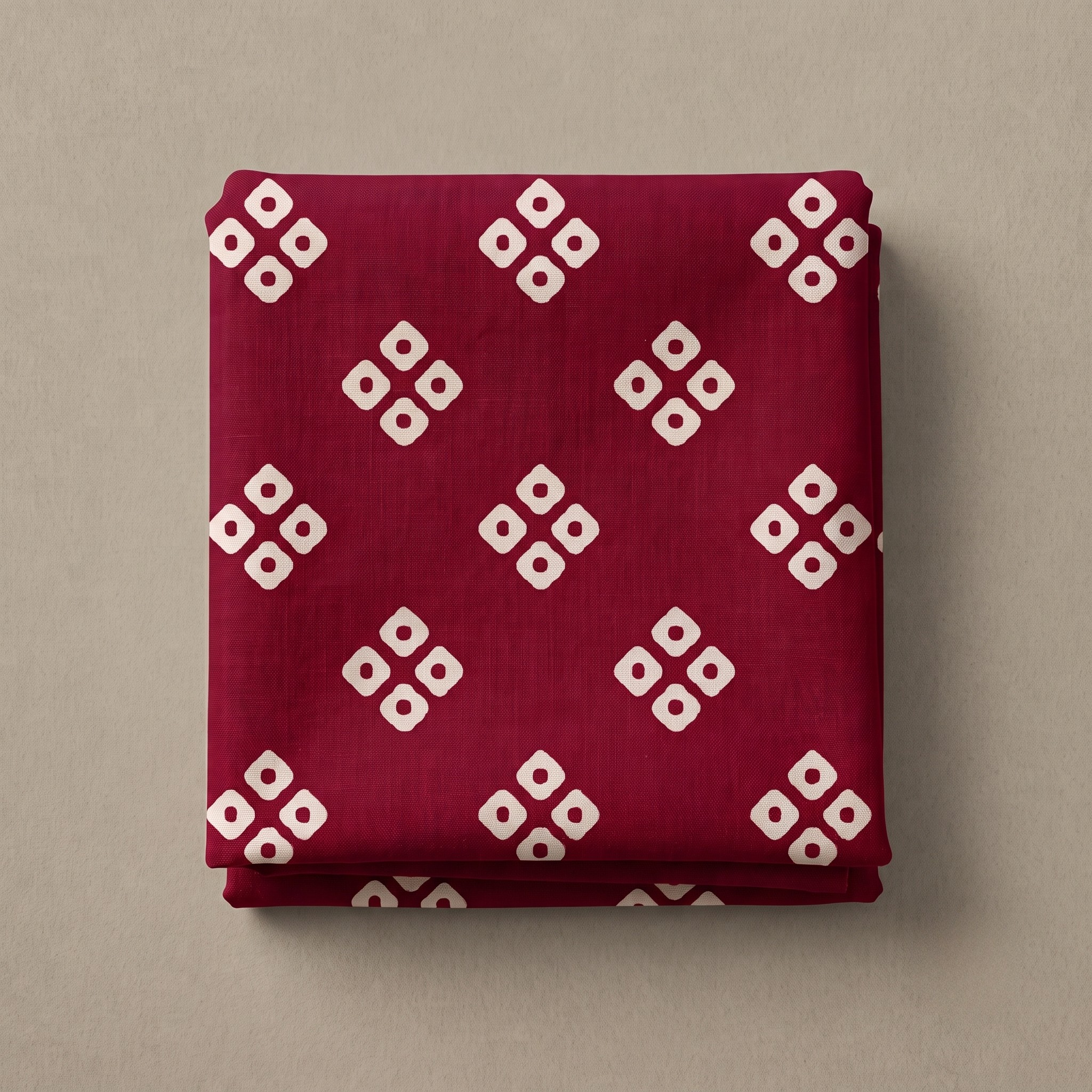 Folded Rani pink bandhani vastra cloth featuring cream geometric prints.