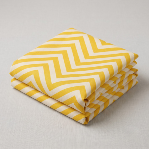Folded sunny yellow and cream chevron leheriya fabric showcasing crisp zig-zag patterns