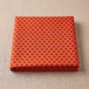 Soft orange and brown printed bandhani vastra for thakorji vastra seva neatly folded on a beige background.